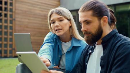 man and woman looking at laptop and tablet