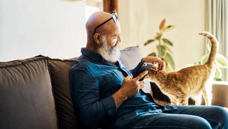 Man using phone with his pet cat