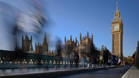 pedestrians passing big ben and houses of parliament