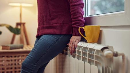 person leaning on a radiator for heat