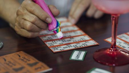 hand holding a pen hovering over a bingo sheet