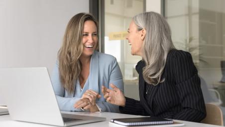 two women laughing in the office