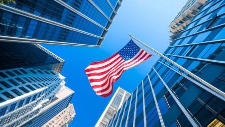us flag between tall skyscrapers