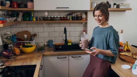 woman drinking protein shake in kitchen
