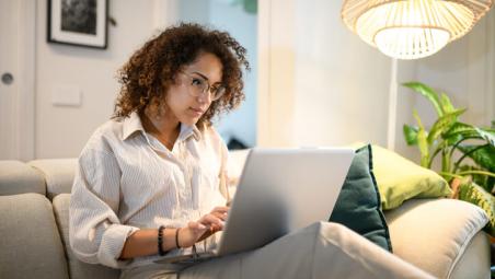 woman using laptop on sofa