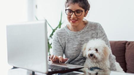 woman using laptop at home with dog