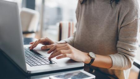 woman wearing a watch using laptop at home