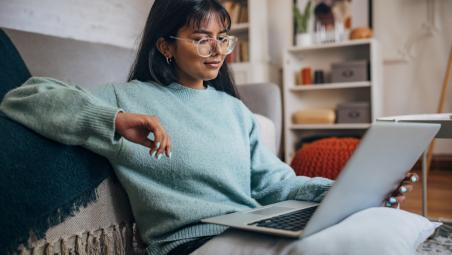 Woman studying notes on laptop