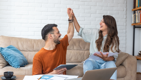 Man and woman high fiving at home